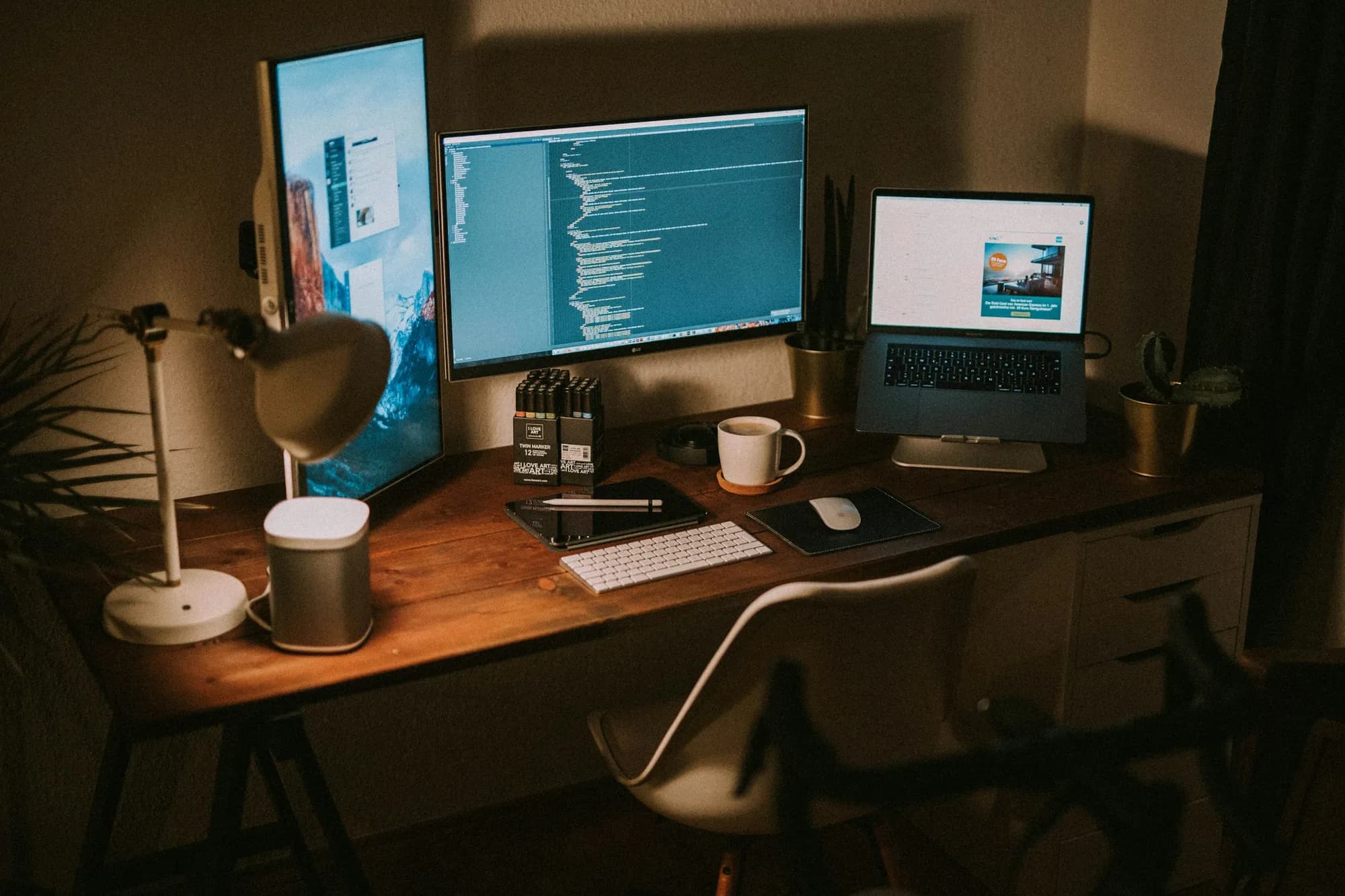 Gece ışığında kod açık monitör, dizüstü bilgisayar ve tablet bulunan çalışma masası